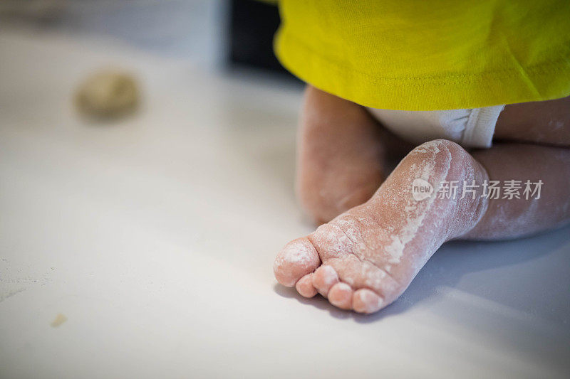 特写婴儿的脚在面粉。烘烤准备阶段。