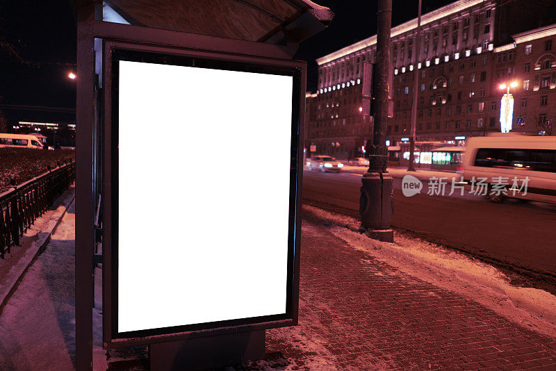 垂直广告城市广告牌格式在公交车站。公交车站在冬天的晚上在城市。广告设计模型与白色的领域。