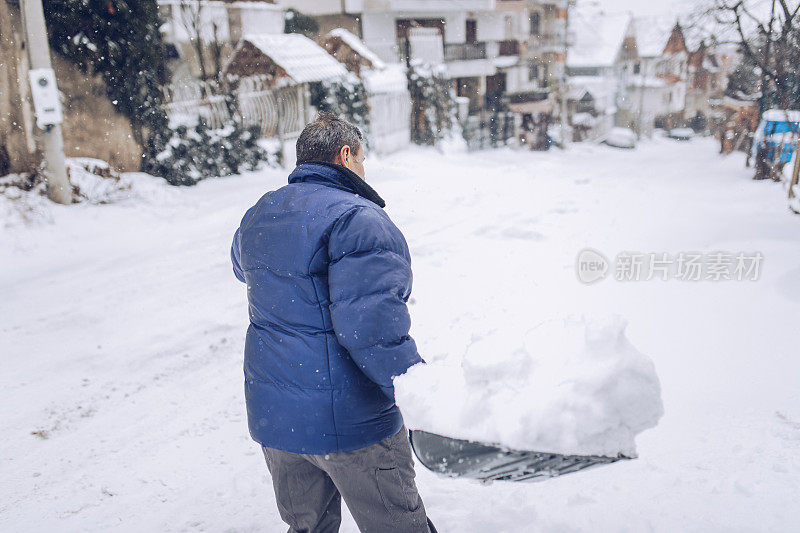 老人在街上扫雪