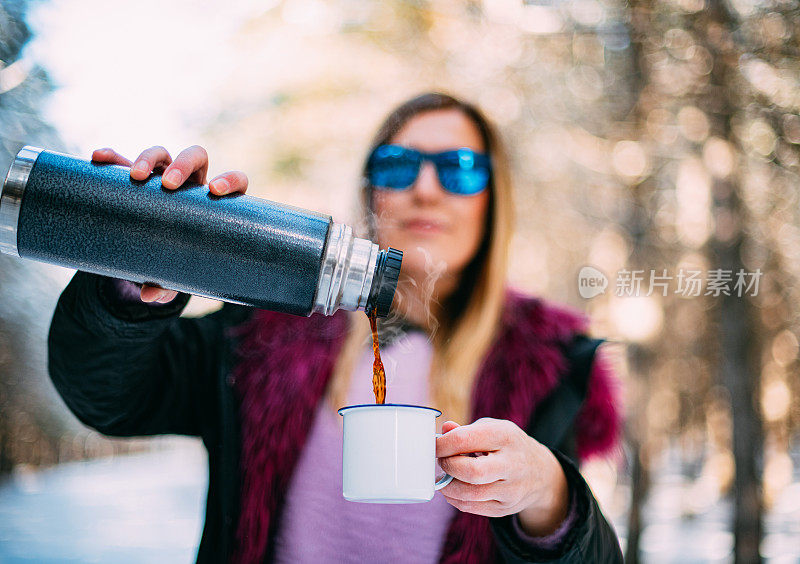 在雪域森林里喝咖啡的可爱女人