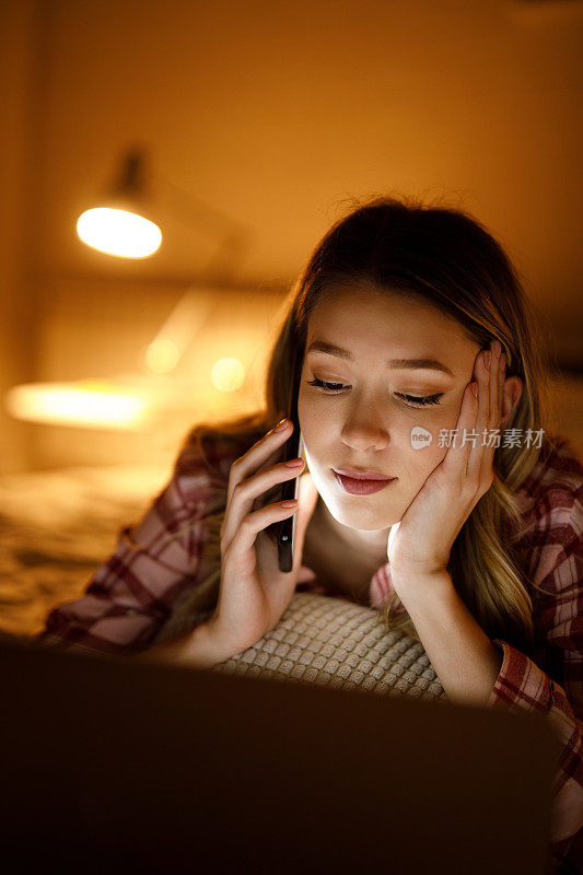 一个年轻女人晚上在卧室里看电影