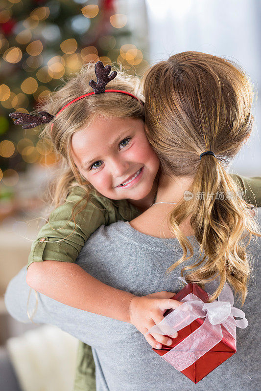 小女孩收到圣诞礼物后拥抱妈妈
