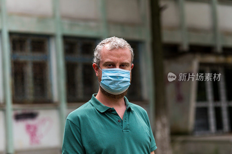 快乐微笑的男人戴着防护面具与城市街道的背景