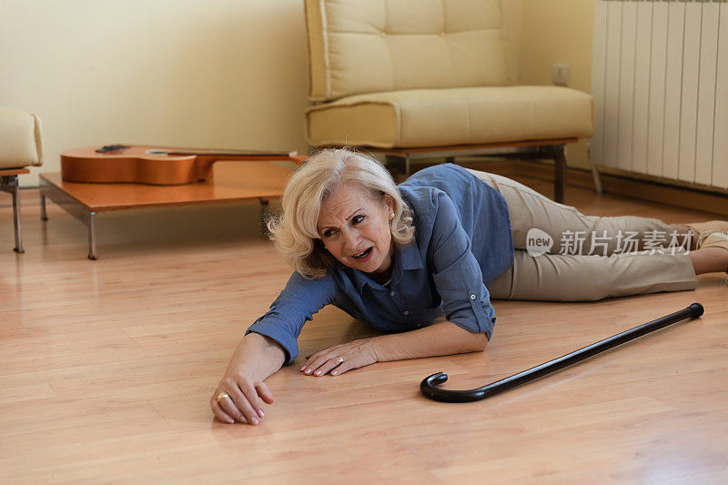 一位身体残疾的老年妇女跌倒在客厅的地板上。