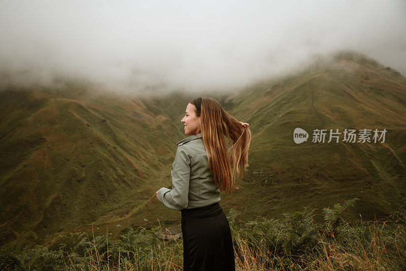 年轻女子被美丽的山景所包围