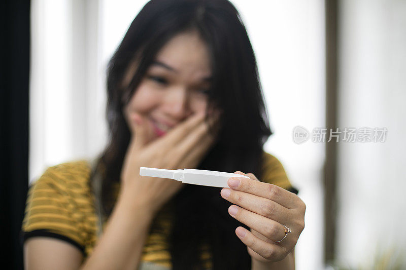 亚洲妇女拿着验孕棒