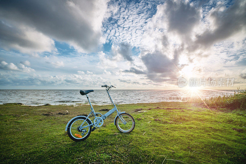日落时海边的可折叠自行车
