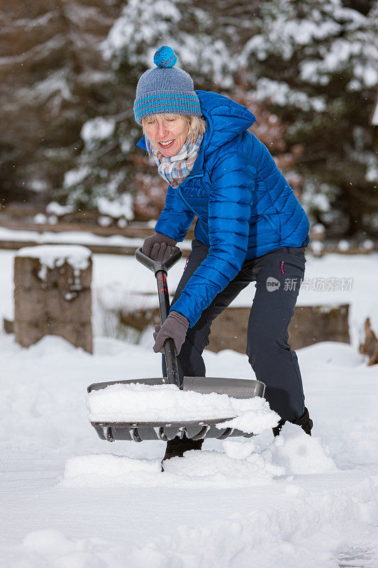 老妇人拿着雪铲