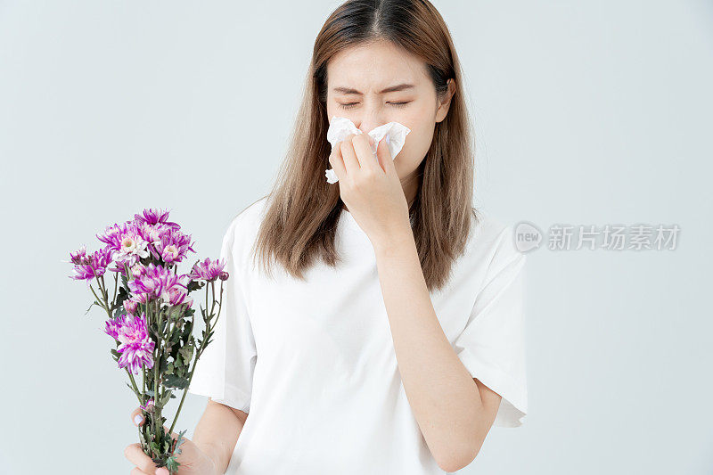 花粉过敏，亚洲年轻女性用手帕打喷嚏或用湿巾吹气，对春天的野花或春天的花朵过敏。过敏反应，呼吸系统问题