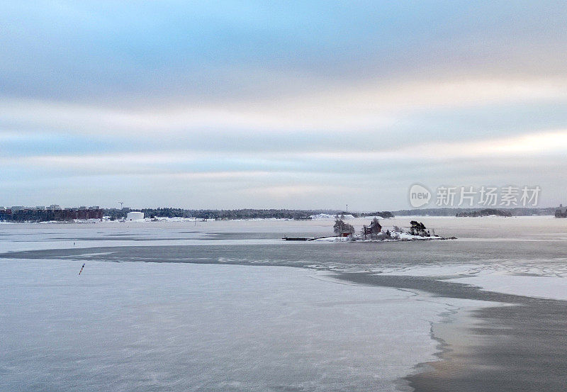 覆盖着冰的波罗的海，一个小岛和赫尔辛基在地平线上。