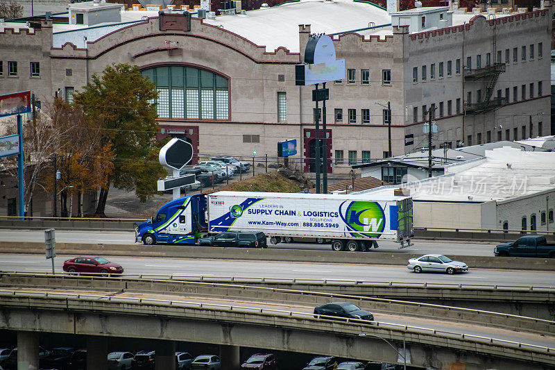 kamway运输公司的半卡车行驶在90号州际公路上，穿过美国华盛顿州斯波坎市的市中心。