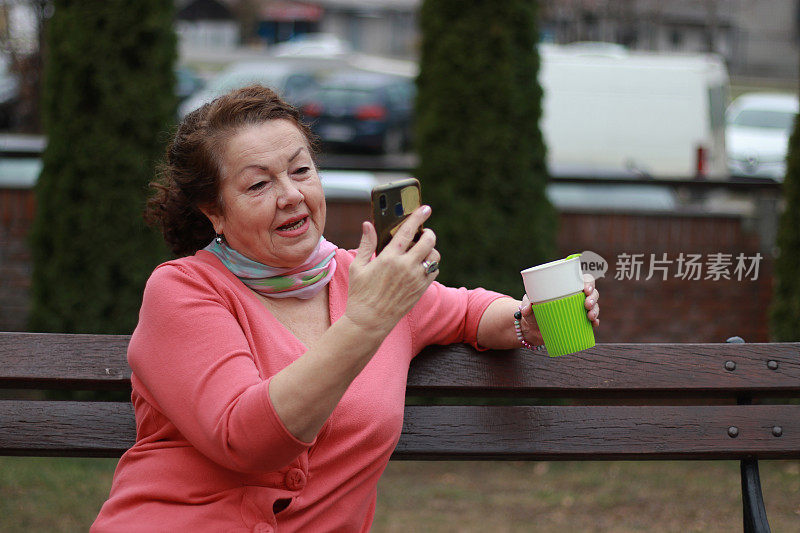 高级妇女放松，使用电话和喝咖啡