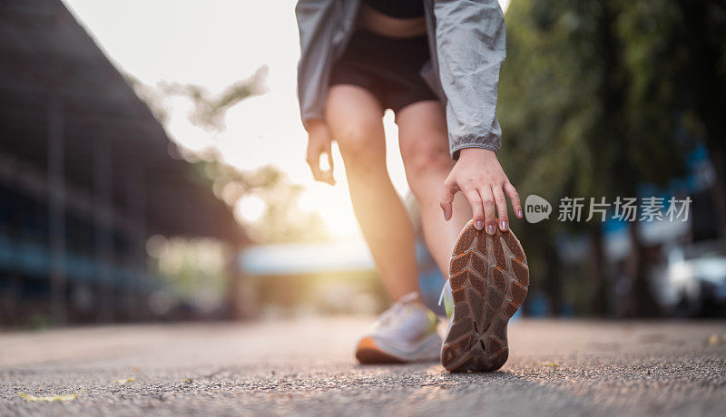 健身，女性在有氧运动、跑步或训练前伸展双腿。体育，健康，女士为户外运动做热身伸展