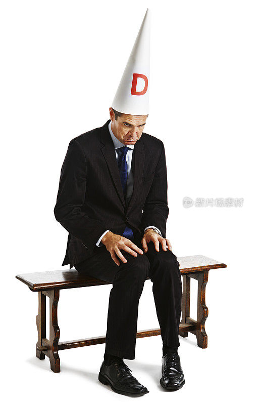 戴着蠢帽的商人坐在淘气的椅子上被惩罚