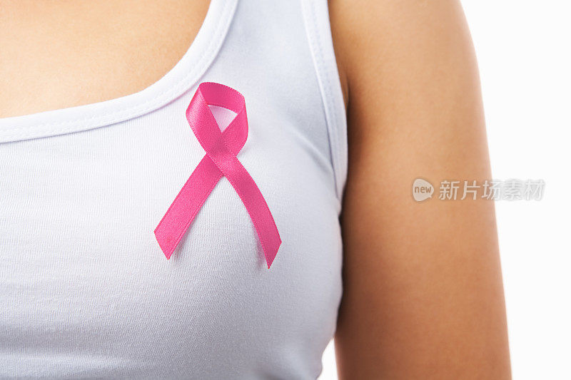 女性胸前佩戴粉色徽章支持乳腺癌