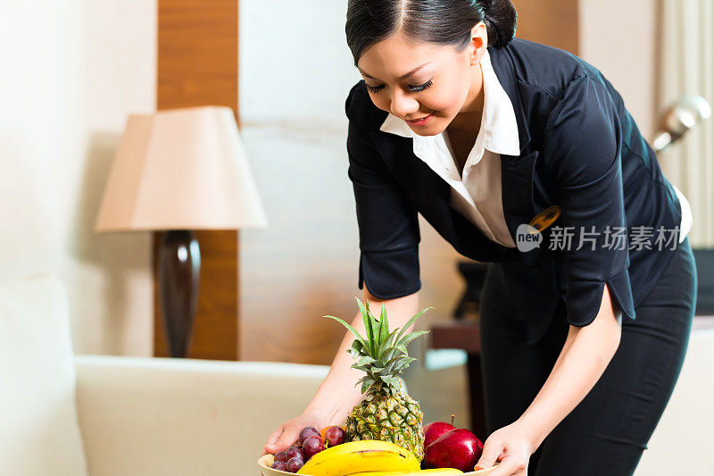 亚洲华人酒店服务员放置水果