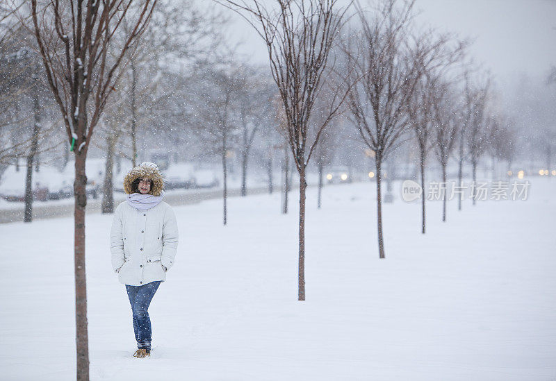 雪下穿着白色夹克的漂亮少女