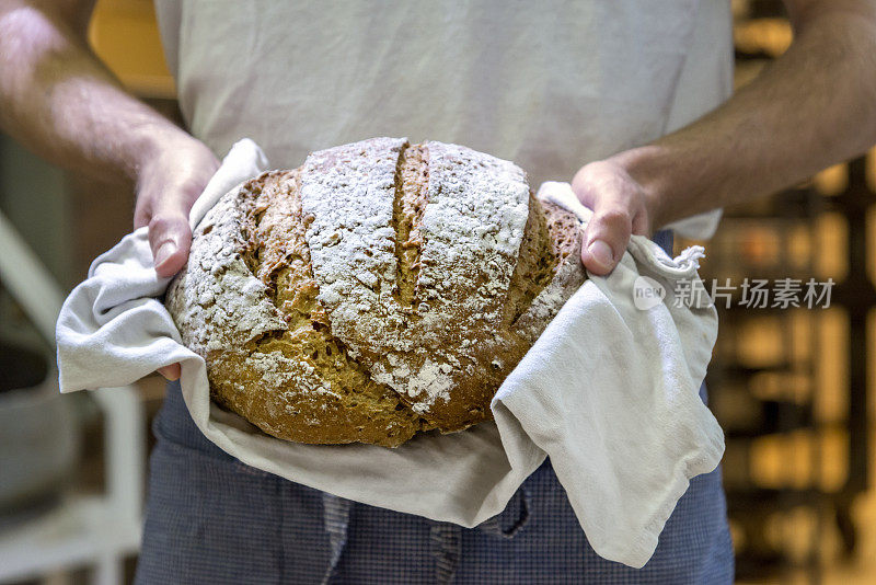 面包师与新鲜，温暖的面包。