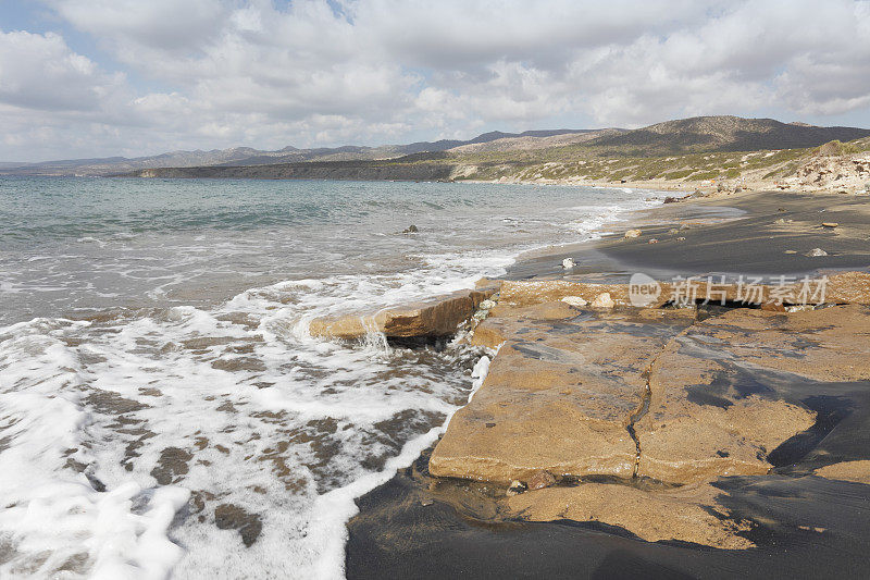孤独的黑色的沙，蓝色的卵石地中海拉腊海滩塞浦路斯