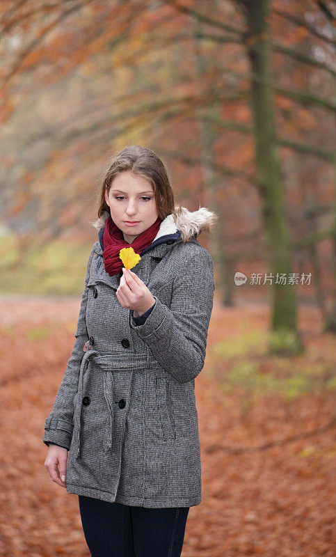 女人在秋天拿着树叶