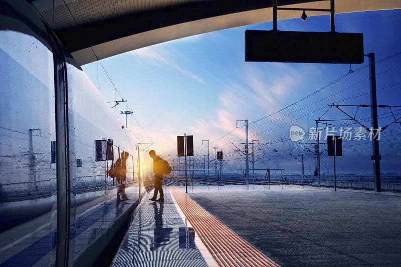 日落时分，旅客在火车站进入列车