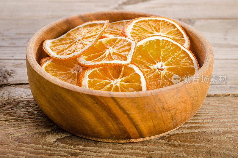 木桌上放着橙子干碗