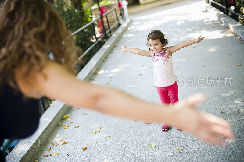 可爱的小女孩和她的妈妈在公园里。