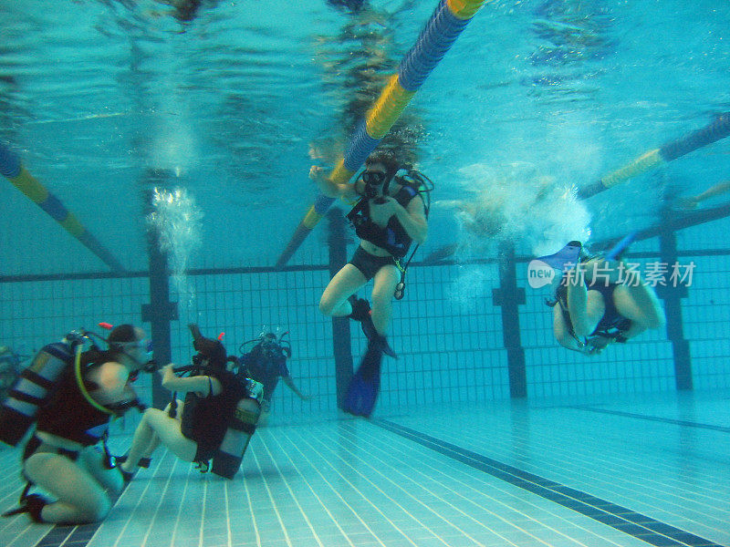 人们在游泳池里潜水的水下照片