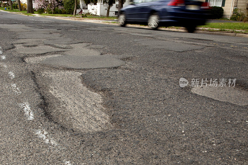 严重坑坑洼洼的郊区道路，坑坑洼洼的特写