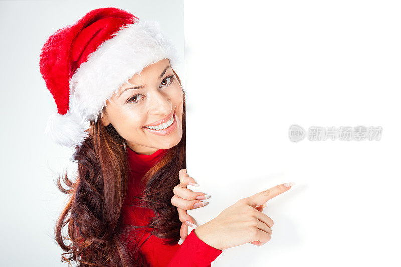 戴着圣诞老人帽的女人指着空白横幅
