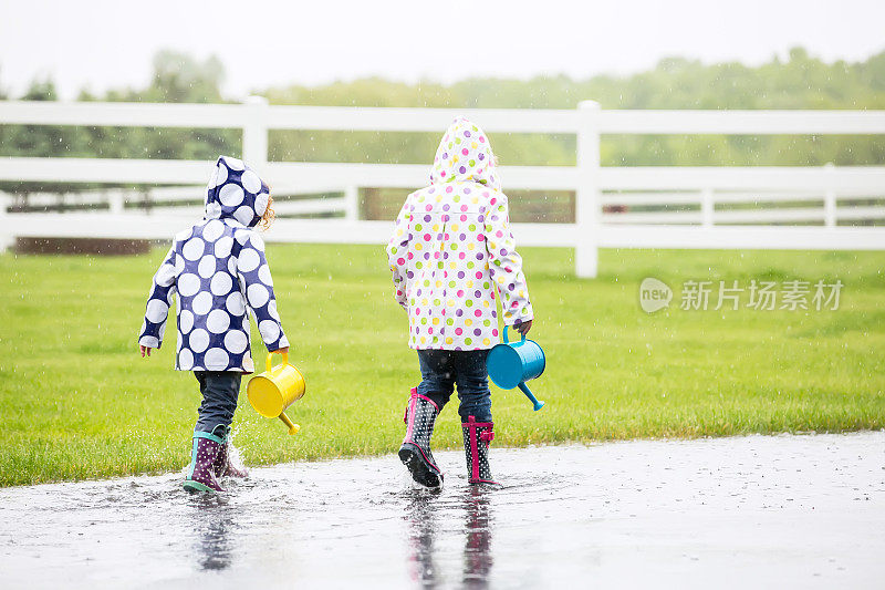 两个小女孩在雨坑里玩
