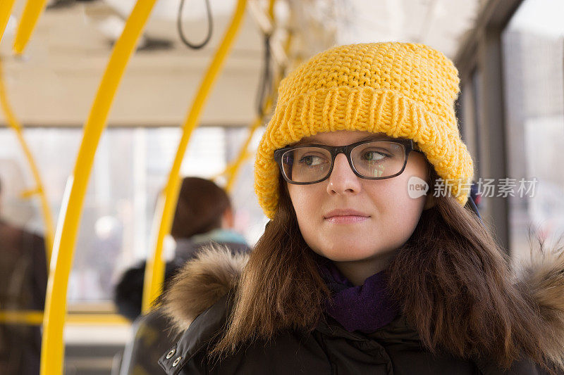 戴黄色帽子的年轻女子乘坐公共交通工具