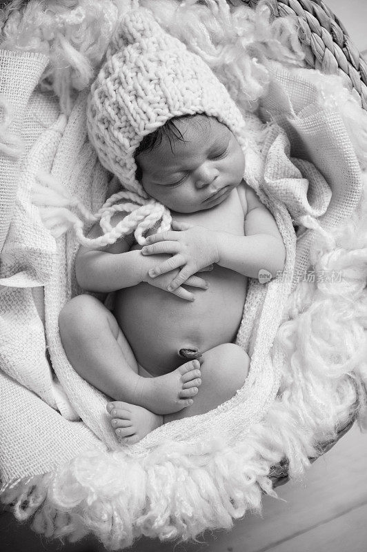 非裔美国婴儿双手合十，在篮子里安静地睡觉