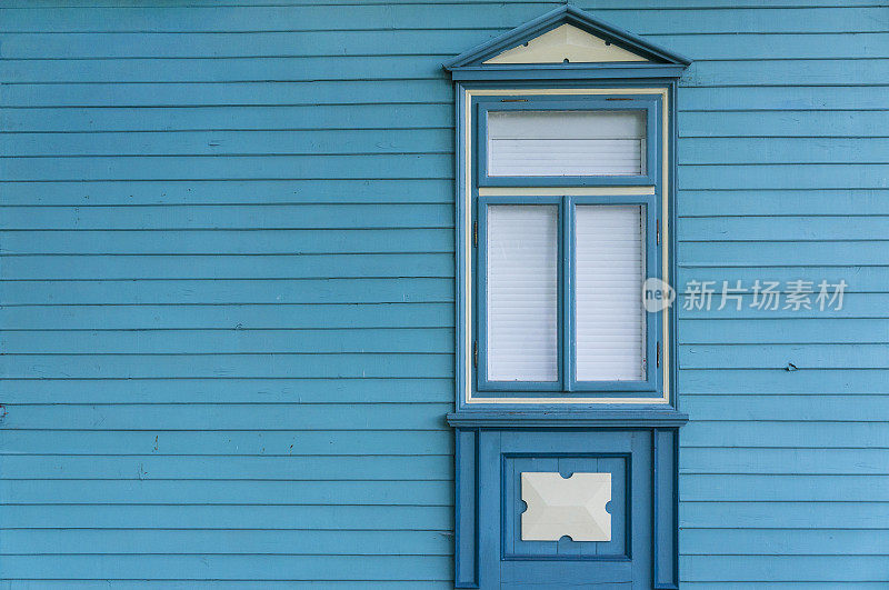带窗户的老木屋的蓝色侧立面