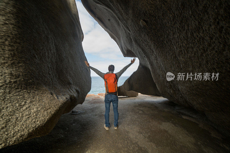 一个快乐的年轻人向“非凡的岩石”伸出了双臂