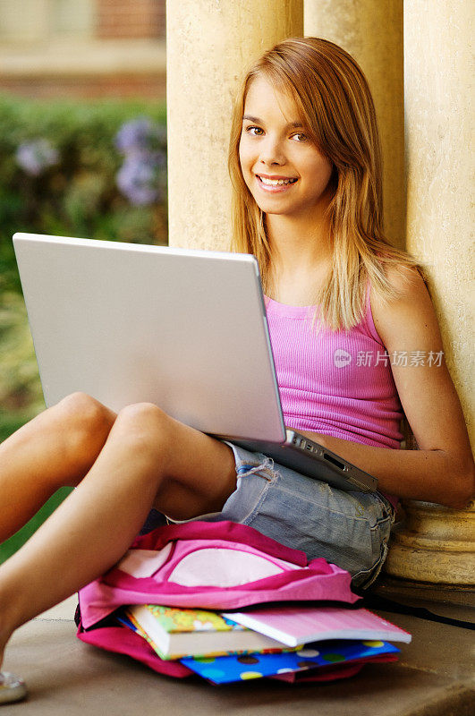 少女在笔记本电脑上做作业