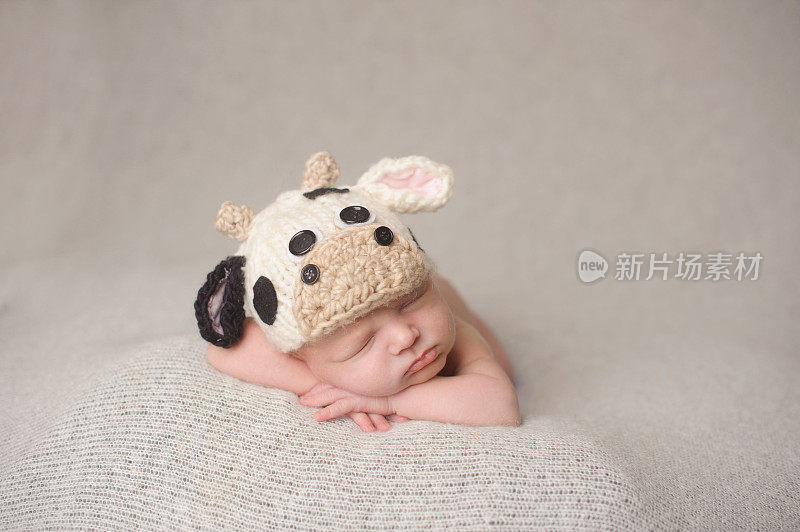 睡着的新生男孩在编织牛帽