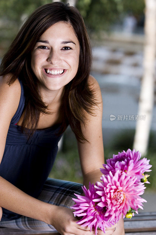 美丽微笑的年轻女子肖像与鲜花，复制空间