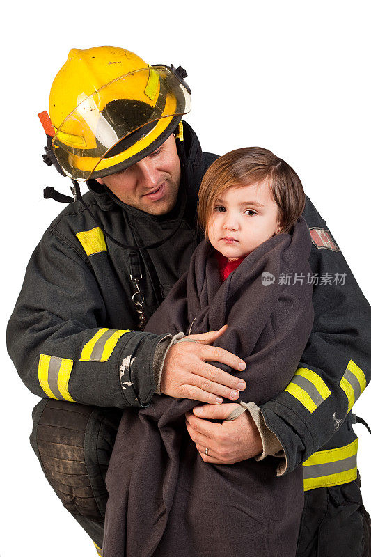 一名消防员抱着裹着毯子的小女孩。