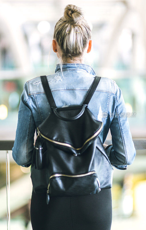 年轻女子背着背包走在欧洲的街道上