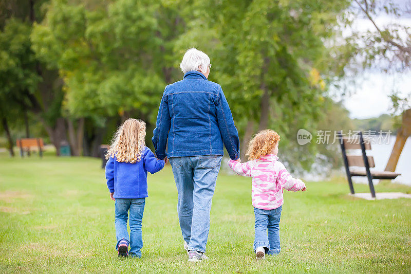 女孩和奶奶手牵着手在公园散步