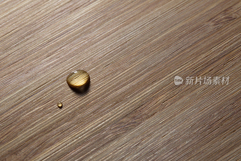 两滴水滴在木头表面，特写