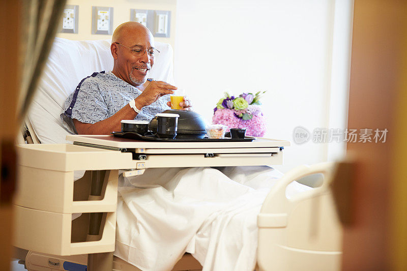 老年男性患者在病床上用餐