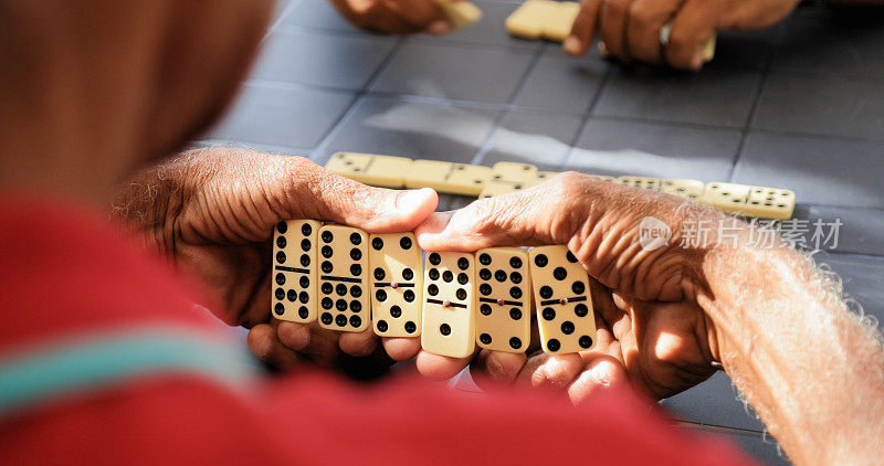 黑人退休老人和朋友玩多米诺骨牌游戏