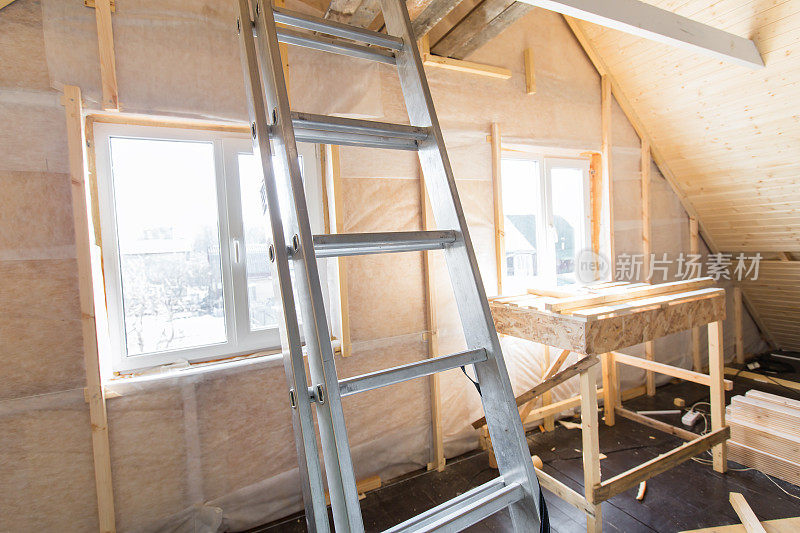 隔热和原木车床准备进行整理。一个未完工的房子的内部视图。工作过程中