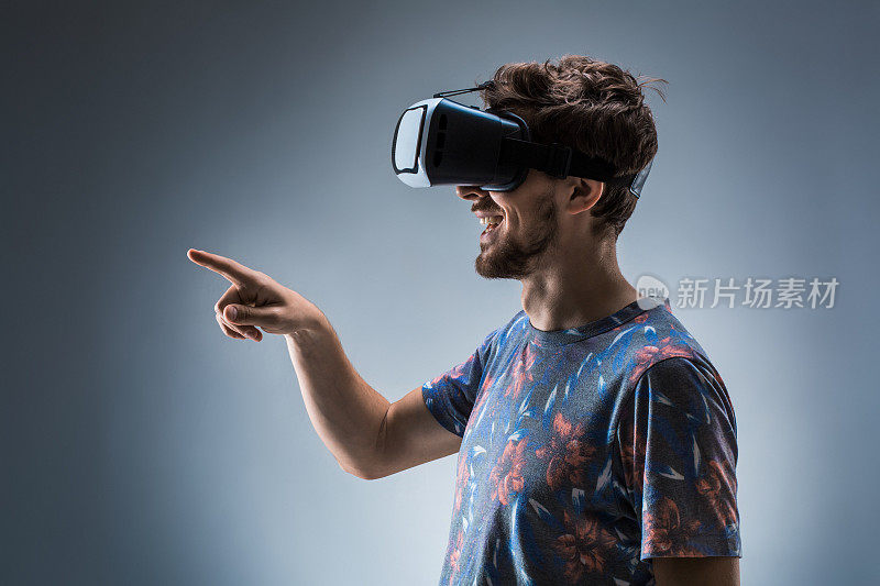 一个年轻人使用VR头盔的侧视图。情绪