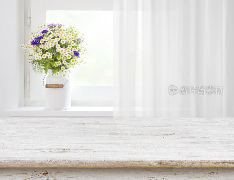 一张质朴的桌子，木窗上放着野花
