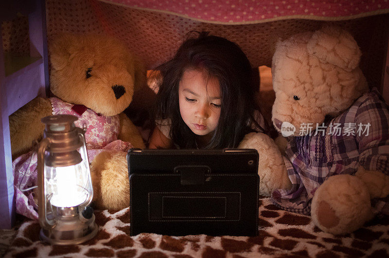 小女孩和泰迪熊在平板电脑上看视频
