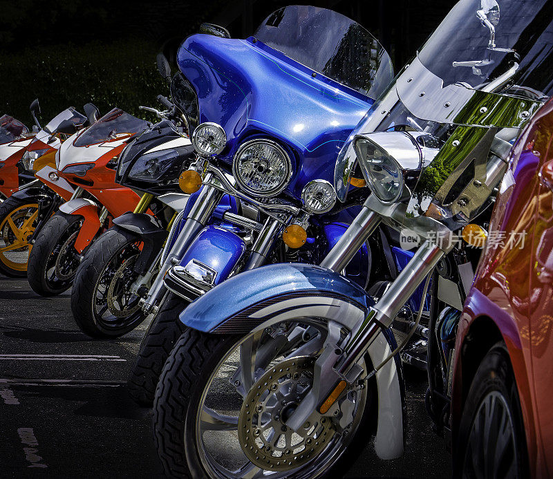 在一个温暖的夏日，在英国湖区的温德米尔湖畔，一排停着的摩托车，这是一个受欢迎的自行车友好的聚会场所。