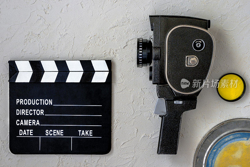 一部电影摄影机，一块拍板，一个胶片盒和一个黄色滤镜